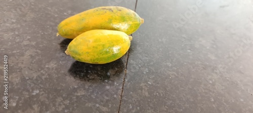 Bild auf Leinwand The image appears to show small, unripe or miniature papaya fruits (Carica papaya) transitioning from green to yellow