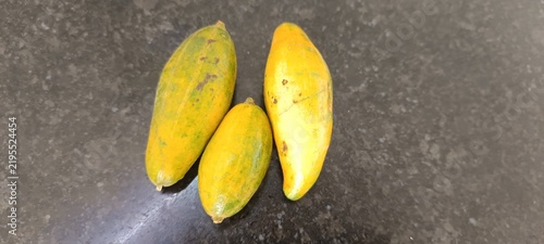 Foto The image appears to show small, unripe or miniature papaya fruits (Carica papaya) transitioning from green to yellow