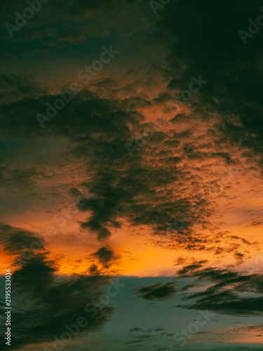 фотографія Intense Fiery Orange Sunset Clouds with Dark Brooding Storm Texture