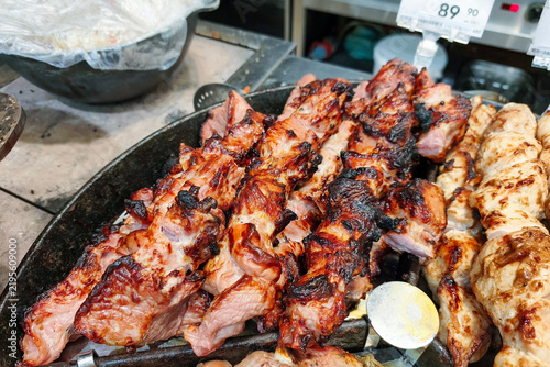 Lamb shashlik is being prepared for sale in one section of a three-compartment pan.