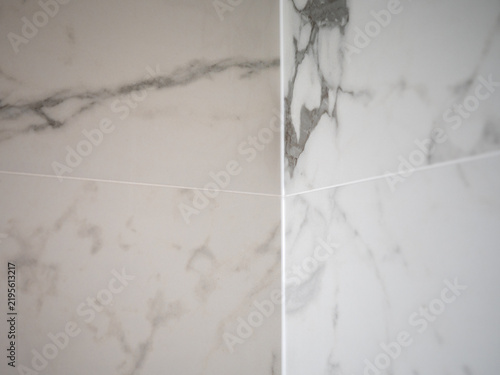 Foto Close-up of a finished ceramic tile outside corner without trim, featuring precisely mitered edges, marble effect, grout joints and detailed craftsmanship in modern interior tiling