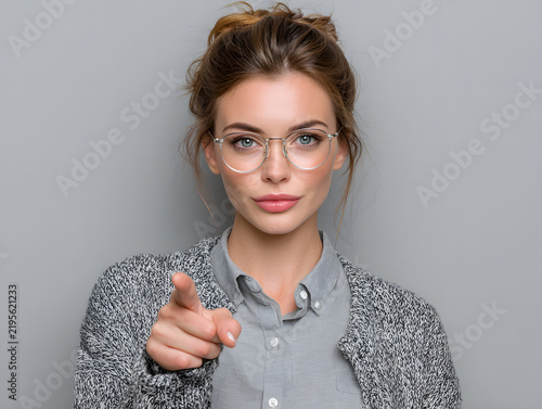 woman with glasses pointing at blank copy space 