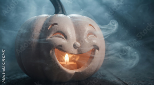 Close up of a laughing white pumpkin jack-o-lantern surrounded by mystical smoke