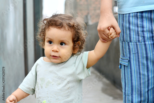 Картината върху платно Cute toddler holds his mommy's hand.