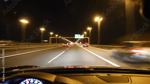 Night highway driving with street lights and illuminated car headlights