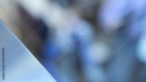 Close-up of blurred office background with blue tones. Sharp foreground contrasts with soft focus. Abstract corporate workspace atmosphere. Modern interior design elements visible