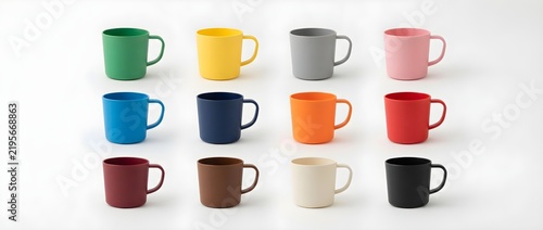 Colorful plastic mugs arranged in a grid. Multi-colored empty drinking cups isolated on a white background, perfect for kitchenware or beverage product mockups.
