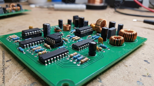 Electronic circuit board with integrated circuits and components on a workbench. 