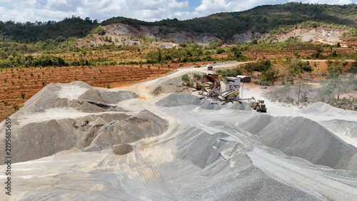 фотографія Industrial stone crushing plant processing gravel piles with heavy machinery at