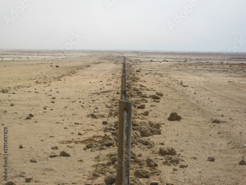 Obraz na plátně Metal fence boundary post in extreme barren desert salt flat landscape