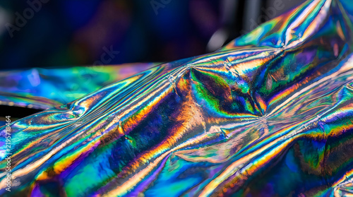 Iridescent foil texture reflecting vibrant rainbow colors with selective focus and macro detail