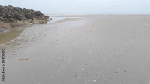 Slow Moving Shot Across a Serene and Moody Beach on an Overcast Day