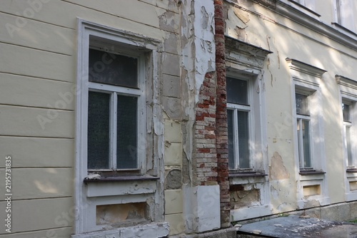 Close-up of decaying wall with peeling paint and bricks.