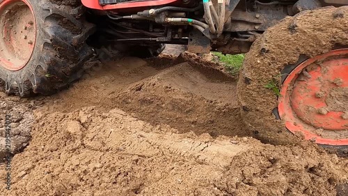 Orange Tractor Driving Through Loose Sand Close Up