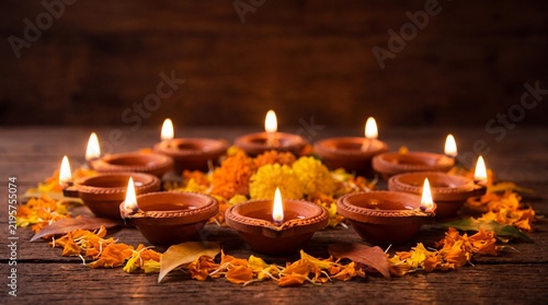 Diya lamps glowing on a wooden table for Diwali festival celebration