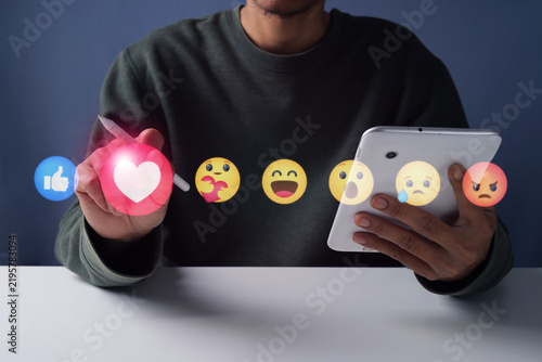 Man Holding Tablet and Stylus Pen Pointing to Media Reaction Icon