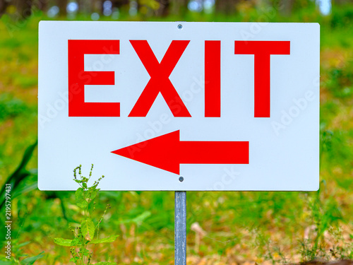 Schild mit roter Aufschrift EXIT und einem Pfeil nach links