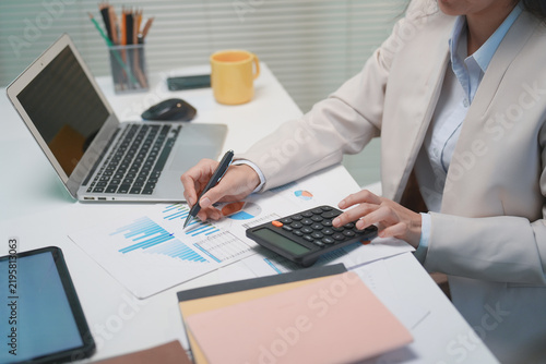 Business Woman Analyzing Financial Documents At Office Desk.