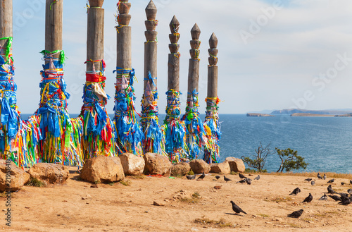 Baikal Lake. Sacred site on Olkhon Island, near Khuzhir. Tourists, pilgrims, Buddhists come to Cape Burkhan to tie colorful ribbons, blue Hadaks, Buddhist prayer flags onto 13 Serge pillars