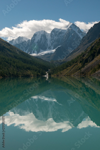 The Lower Shavlinskoye lake in the morning with mountain peaks Dream, Fairy Tale and Beauty reflecting in the water, Russian Federation