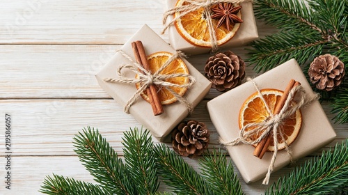 Christmas kraft gift boxes with dried oranges, cinnamon and fir branches
