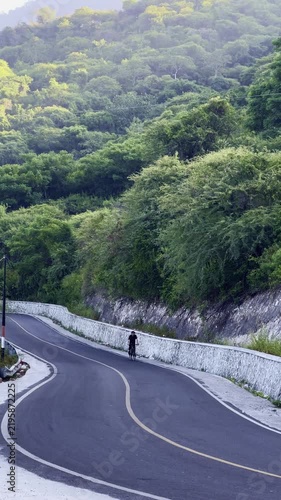 Cyclist Riding on a Scenic Mountain Road