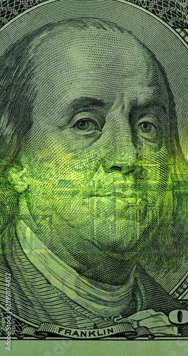 Benjamin Franklin on 100 Dollar Bill with Green Scan. Benjamin Franklin portrait on 100 dollar bill glows under moving green security scan. Banknote image shifts from top to bottom.