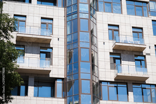 Modern residential building facade with balconies and blue glass