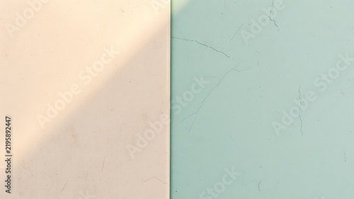 Pale peach and mint green wall with light shadow and cracks texture surface