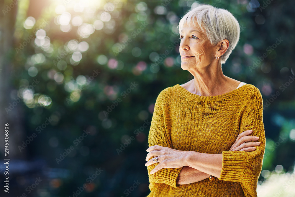 Obraz premium Garden, thinking and senior woman with morning for reflection, nostalgia and daydreaming outdoor. Retirement, weekend and old person in nature with bokeh for space, memory and relax with arms crossed