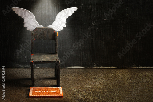 Empty black chair with angel wings