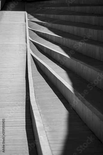 Minimalist black and white view of geometric concrete steps with dramatic light and shadows