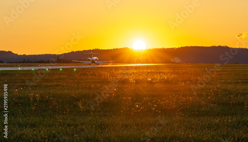 Private jet touching down into a golden sunset
