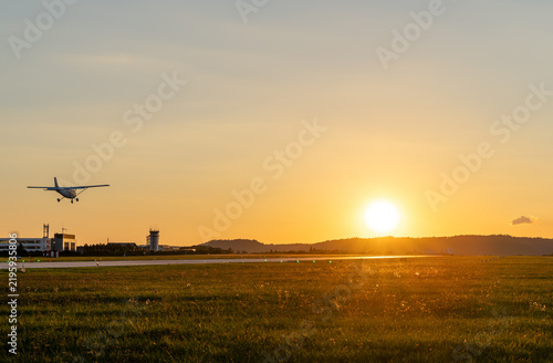 Single-engine aircraft landing at sunset
