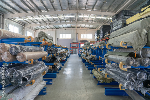 Warehouse workshop real scene with cloth rolls neatly stored on three-dimensional shelves