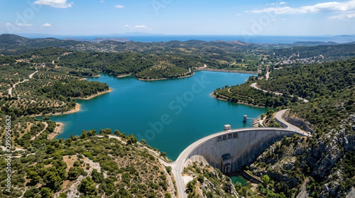 Majestic Dam Holds Back Vast Turquoise Reservoir In Lush Green Landscape