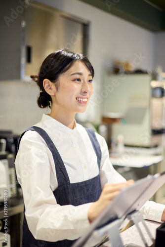 Quadro su tela カフェで笑顔で会計業務を行う女性スタッフ