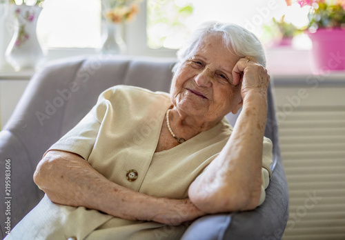 Portrait of an elderly woman sitting in armchair at home
