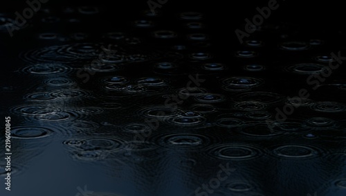 Raindrops on dark water with ripples