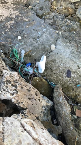 Vertical video. Garbage on the seashore, the consequences of environmental pollution, the importance of environmental responsibility, recycling, and waste reduction