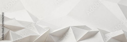 Minimalist white paper background with geometric origami folds. Abstract 3D low poly texture for corporate branding. Clean architectural paper craft backdrop for website header design.