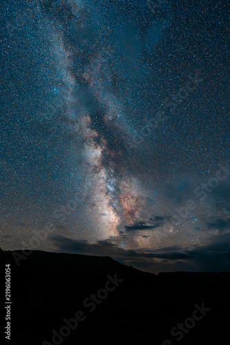 Vertical Milky Way Galaxy Rising Over Dark Mountain Silhouette with Clouds