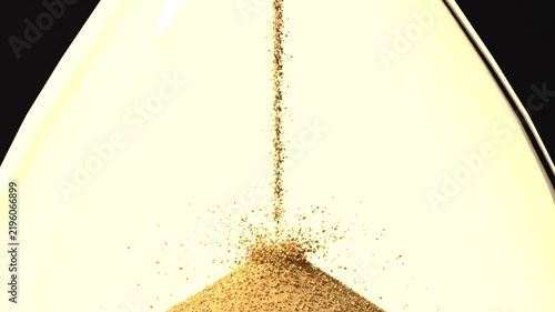 Streaming golden sand forming conical pile in lower bulb after hourglass flip, measuring time