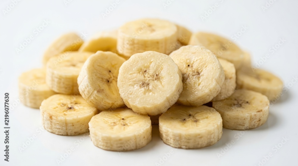 Fototapeta premium Stack of Sliced Ripe Yellow Banana Rounds Isolated on White Background