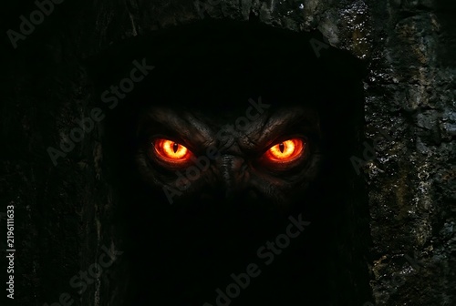 Glowing Orange Eyes of Mysterious Owl in Dark Night Forest.