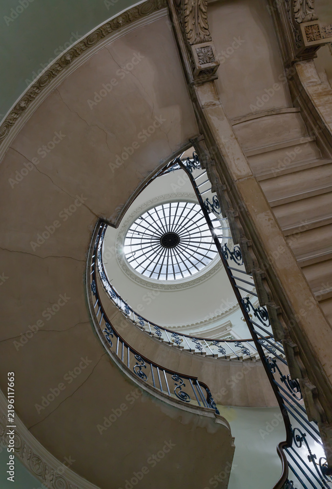 Fototapeta premium Looking up of the Nelson Staircase within Somerset House in London, a grand spiral staircase inside a neoclassical building, featuring a prominent circular oculus (skylight) at the top and the intrica