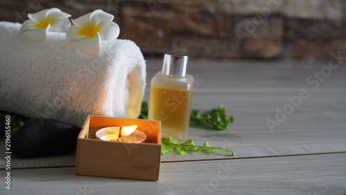 фотографія Spa wellness arrangement featuring a rolled white towel decorated with white plu