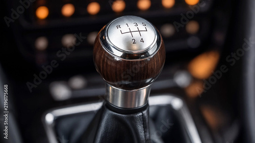 Manual gear shifter with walnut wood and aluminum knob in a car interior