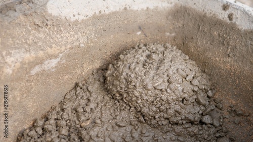 Obraz na płótnie Close up view of wet concrete mix with gravel and cement slurry inside worn cont