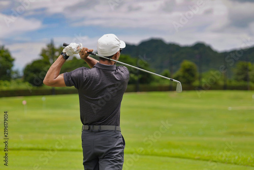 Asian golfer putting on a golf course.